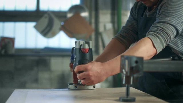 Carpenter polishing wood with electrical sanding machine