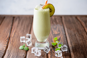 Fresh pistachio cocktail with kiwi on a wooden background