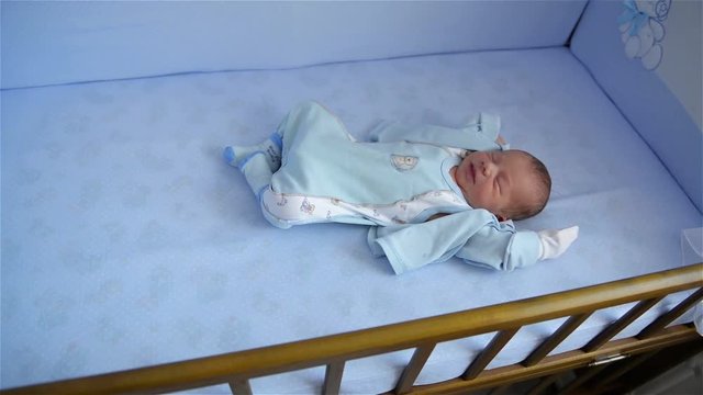 New born child in wooden co-sleeper crib, Infant sleeping