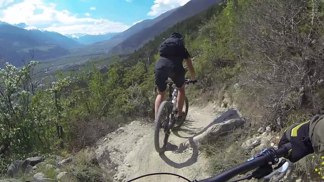 Mountain bike riders riding a downhill  single trail in Vinschgau northern Italy. Shot was taken with body action cam from riders point of view.