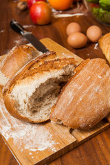 Freshly baked bread broken in the middle on wooden board
