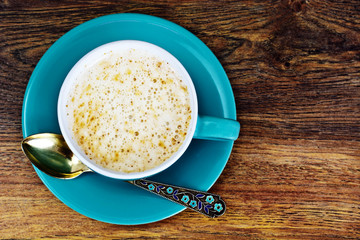 Coffee with milk, cappuccino in a blue retro cup