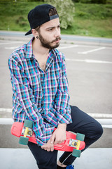 Stylish young guy on a red skateboard © ces