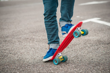 Stylish young guy on a red skateboard