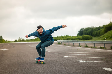 Stylish young guy on a red skateboard