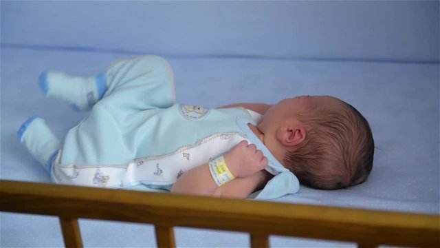 New born child in wooden co-sleeper crib, Infant sleeping