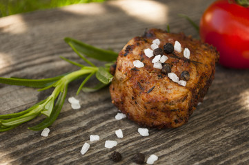 Gegrilltes Filet vom Grill mit Salz- und Pfefferkörnern mit Rosmarin und Tomate auf Holz
