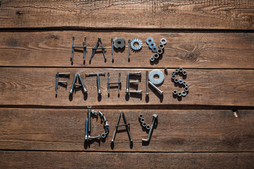 Happy Father's Day. Greeting card made of metallic bolts and iron nails