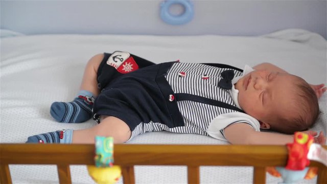 New born child in wooden co-sleeper crib, Infant sleeping