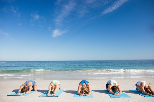 People Doing Yoga On The Beach