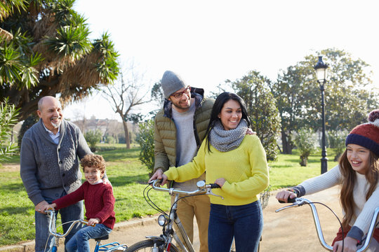 Multi generation family in park on with bicycles