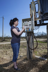 Technician woman reading the electricity meter to check consumpt