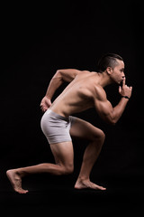 fitness model performing pose with black background