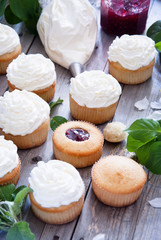 Obraz na płótnie Canvas Cupcakes with butter cream and spring white flowers
