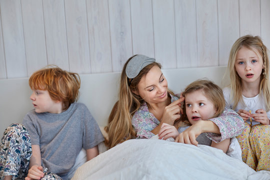 Mother and children together in bed