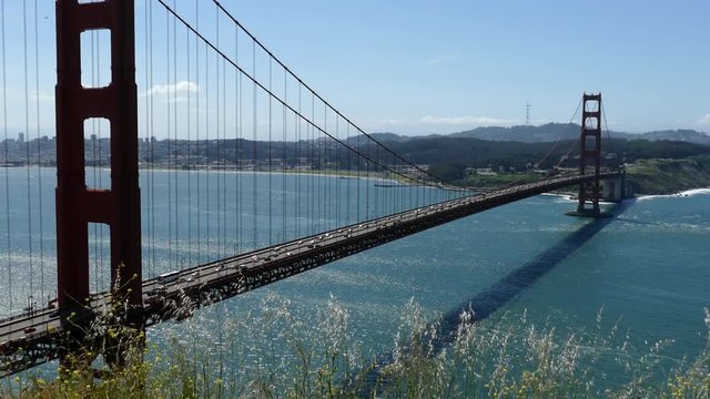 Golden Gate Bridge on grassy wind blown hilltop above San Francisco with zoom in.