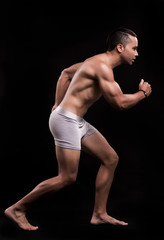 fitness model performing pose with black background