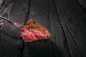 grilled meat. impale a piece of steak on a fork.