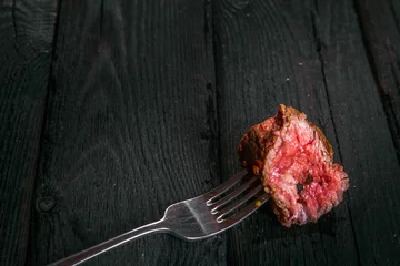 Gardinen grilled meat. impale a piece of steak on a fork. © roggozub