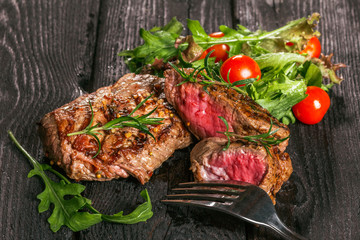 steak and salad on a wooden table