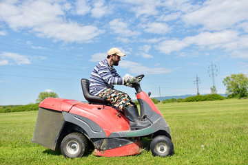 Fototapeta premium Smiling handicapped boy on lawn mower