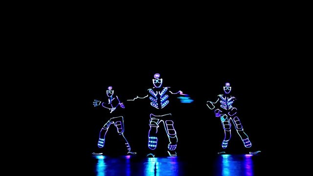 4 people dancing in costumes of LEDs