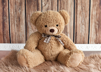 Teddy bear sitting on wooden background