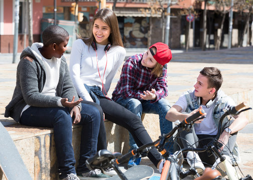 teens chatting near bikes