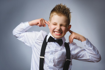 Closeup portrait of handsome boy covering his ears, observing. Hear nothing. Human emotions, facial expressions
