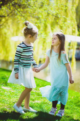 Fototapeta premium cute stylish little girls playing at park outdoor