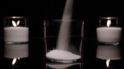 Pouring granulated wax in glass. Making decorative glass candle.