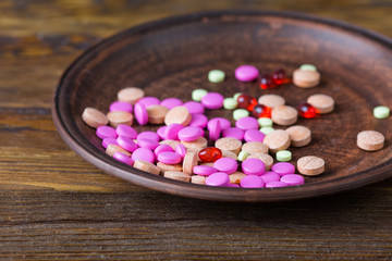 pills on a plate on a wooden background
