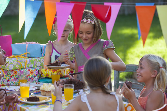 Girl serving friends birthday cake