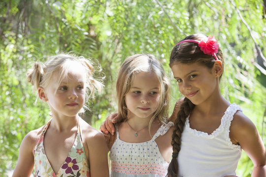 Candid portrait of three girls in garden