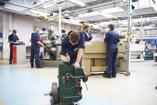 Male student sharpening tools in college workshop