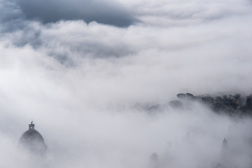 Church of Cortona immersed in fog in Tuscany - Italy