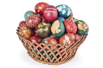 Fototapeta premium Easter eggs in woven basket isolated on white background