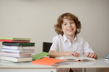 Smiling boy sitting at a school desk