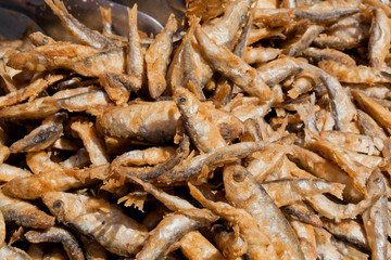 Many small fish fried in oil and ready for food supply