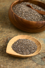 Gesunde Chia Samen (lat. Salvia hispanica) die als Superfood bezeichnet werden, fotografiert mit natürlichem Licht (Selektiver Fokus, Fokus ein Drittel in die Chia Samen auf dem kleinen Teller)