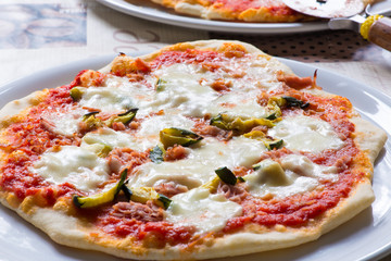 Pizza with mozzarella, zucchini, tomato, ham