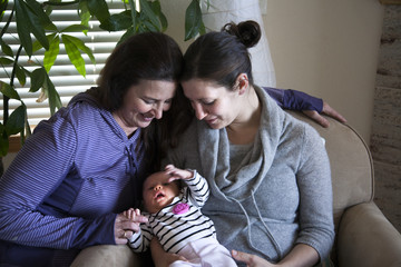 Baby girl sitting with mother and grandmother