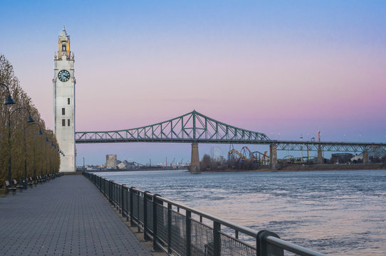Waterfront view of clock tower and Jacques Cartier bridge at sunset, Montreal, Quebec, Canada