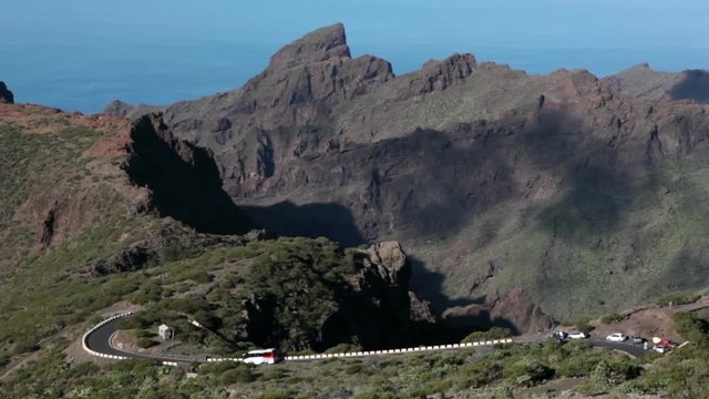 Touristic bus and cars drive narrow road TF-436. Mountain zig-zag road TF-436 from Masca village to Santiago del Teide. Tenerife, Spain
