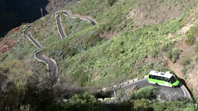 Passenger bus drives on mountain zig-zag road TF-436 from Masca village to Santiago del Teide. Tenerife, Spain
