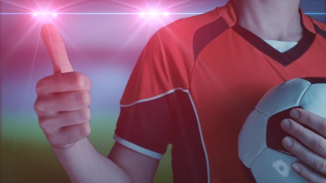 footballeur faisant le signe du pouce lev&eacute; dans un stade