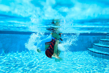 Underwater little boy with mask in swimming pool