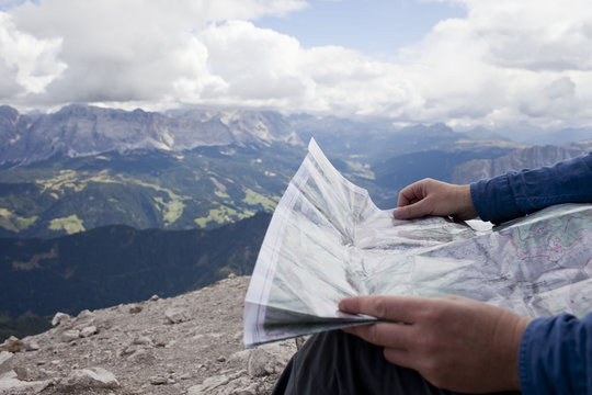 Cropped shot of male hiker on top of mountain holding map, Peitlerkofel, South Tyrol, Italy