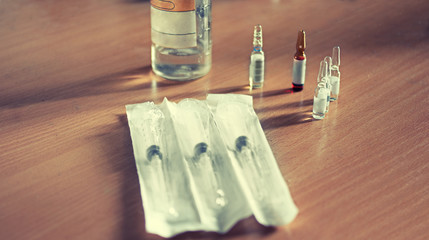 Medical syringe and liquid vial on wooden table background  toned image, instagram effect. Selective focus, very shallow dof