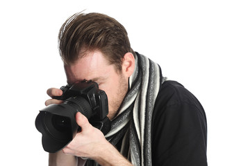 Attractive photographer with a digital slr camera, wearing a black tshirt, scarf and jeans. Standing against a white background.